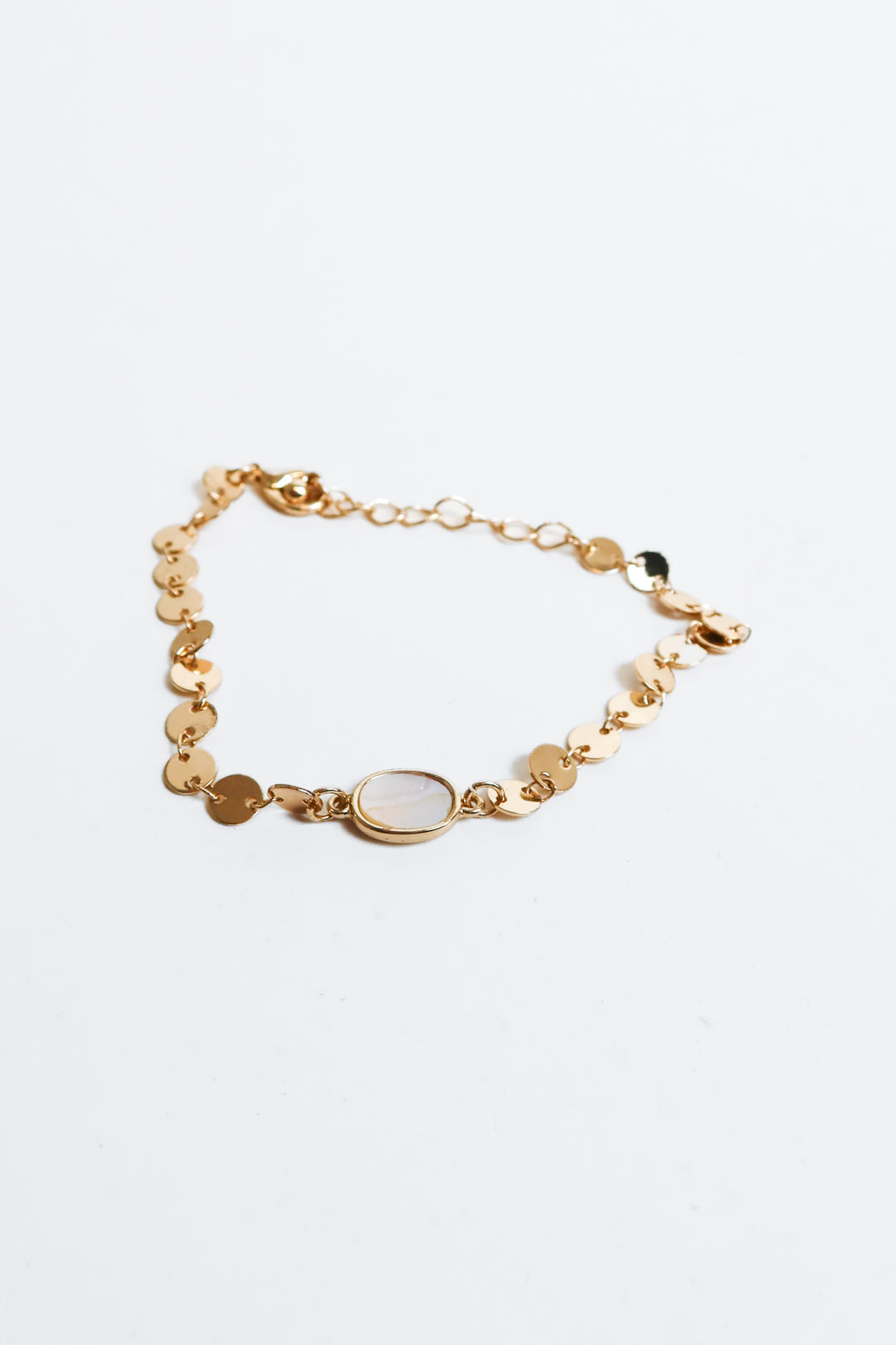 gold bracelet with white gem